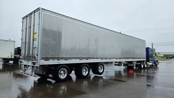 Vanguard reefer trailer backed into a loading dock in heavy rain