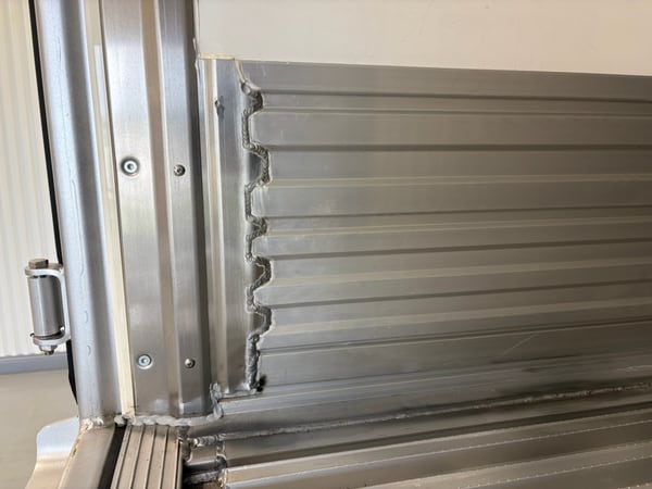 Welded anti-snag scuff transition joining the side wall scuff band inside a Vanguard reefer