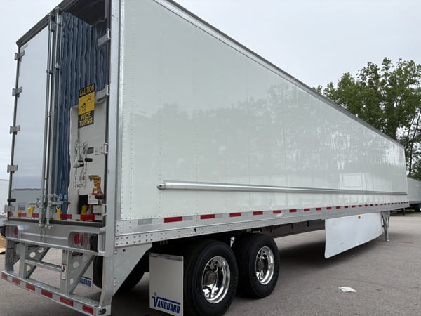 Side and rear quarter of a white Vanguard refrigerated trailer showing the smooth exterior wall and rear structure
