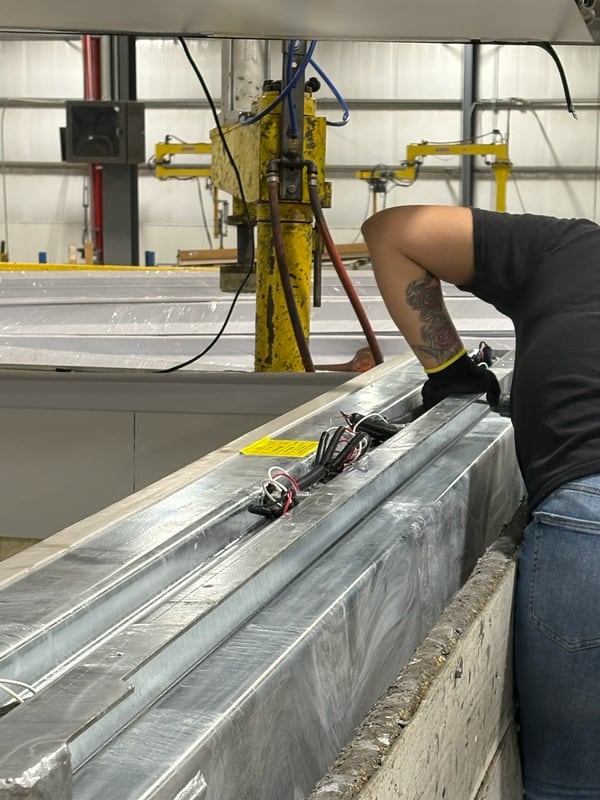 A Vanguard worker fabricating an aluminum bulkhead frame on the plant floor