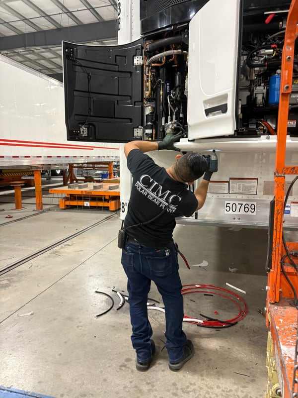 A CIMC technician servicing the refrigeration unit on a Vanguard reefer trailer