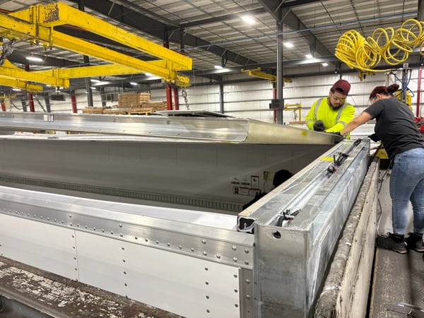 Two Vanguard workers assembling the roof of a refrigerated trailer on the plant floor