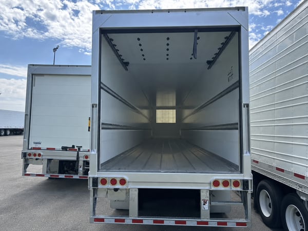 Vanguard refrigerated trailer with roll-up rear door open, showing the interior cargo box